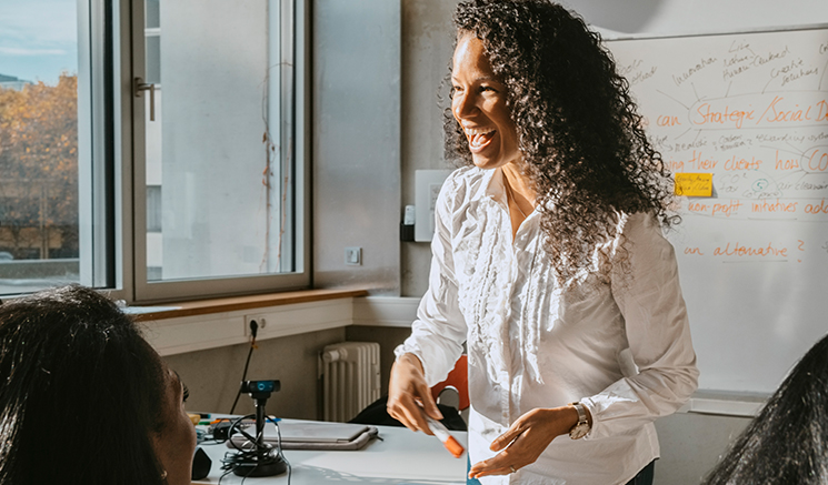 Young woman laughing and holding a marker